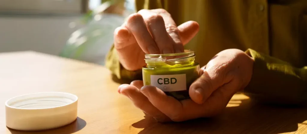 Person applying plant-based oil to shoulder for pain relief